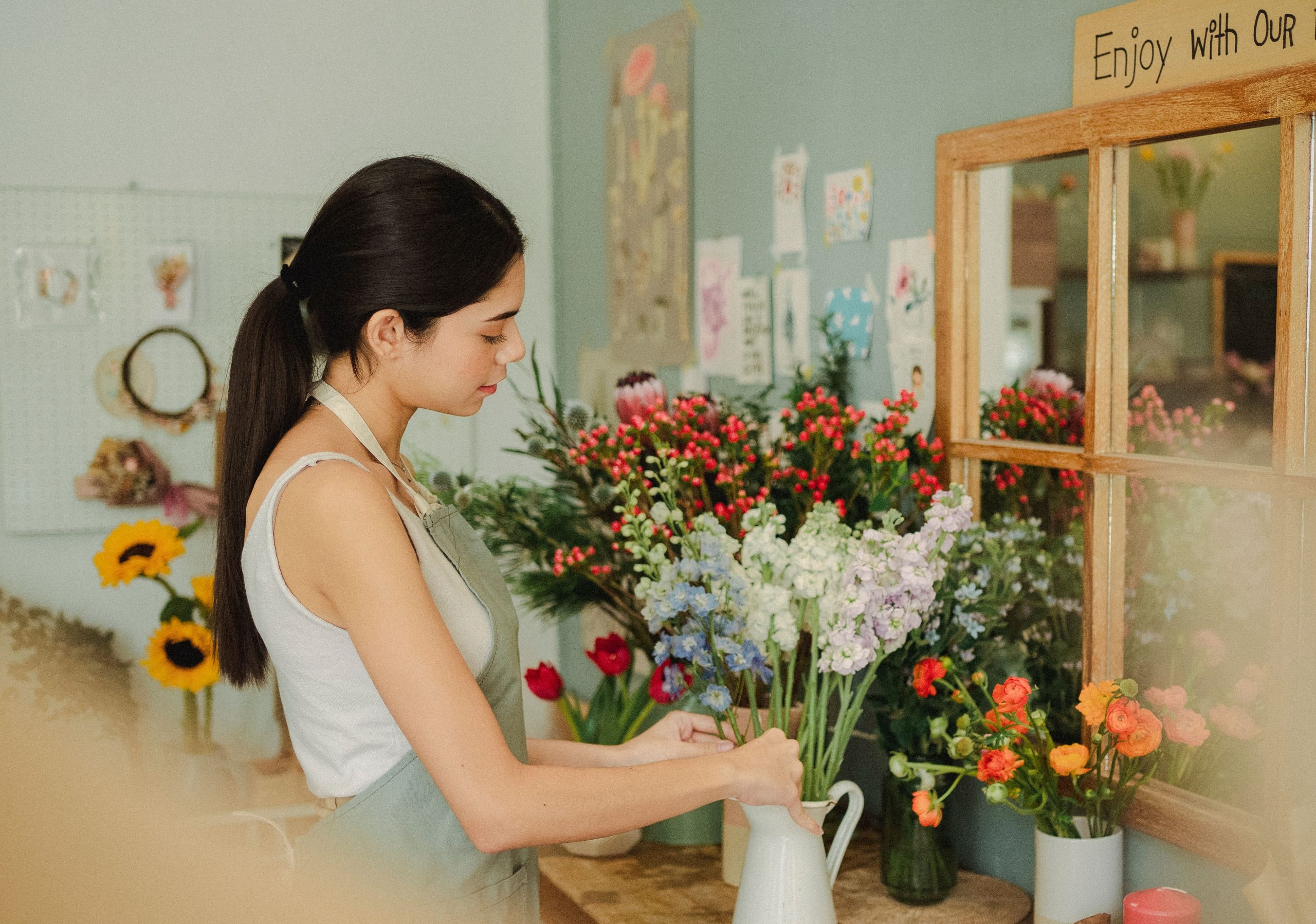 Fleuriste arrangeant des fleurs fraiches dans vase