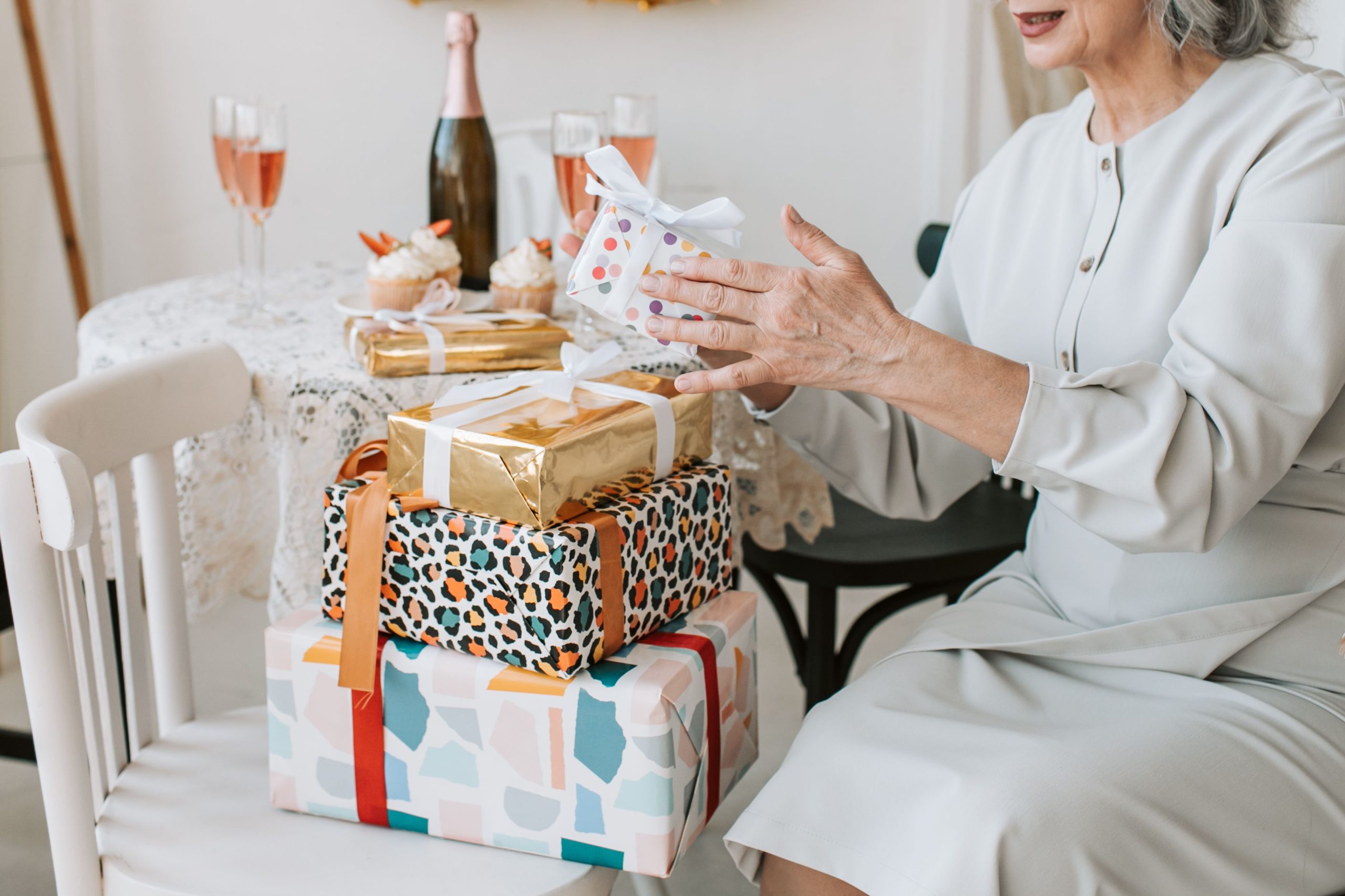 Femme senior célèbre avec cadeaux magnifiquement emballés