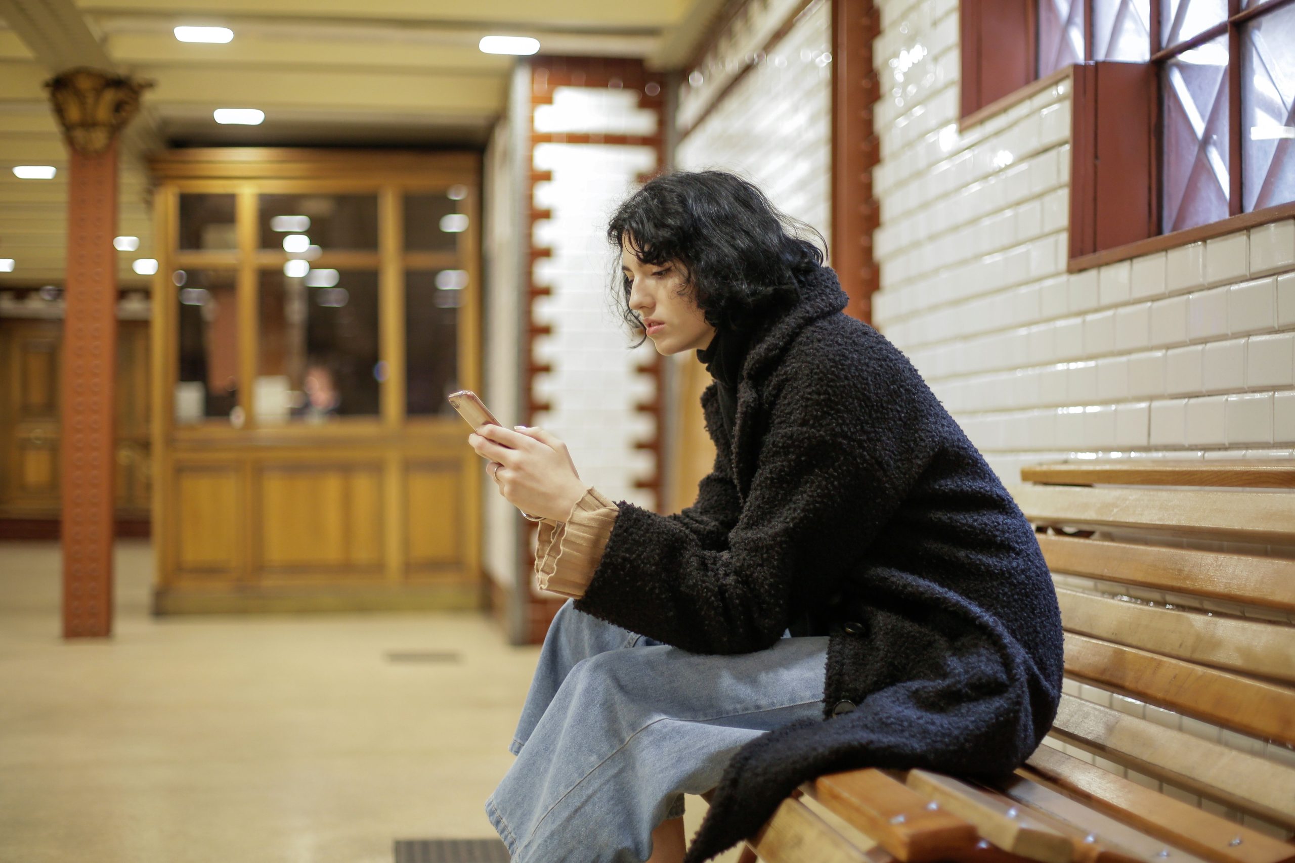 Jeune femme utilisant son smartphone sur un banc