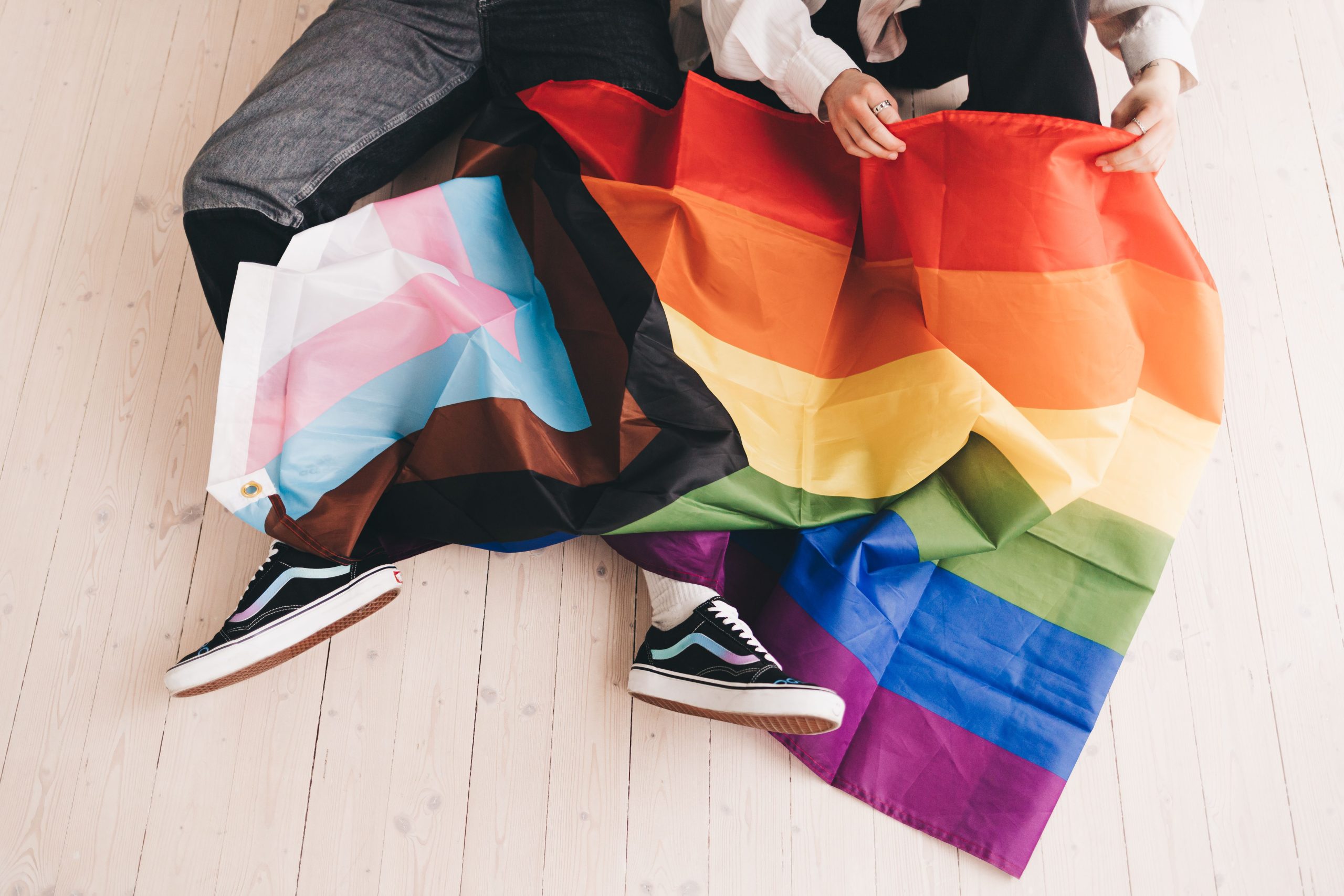 Deux personnes avec drapeau Progress Pride inclusif
