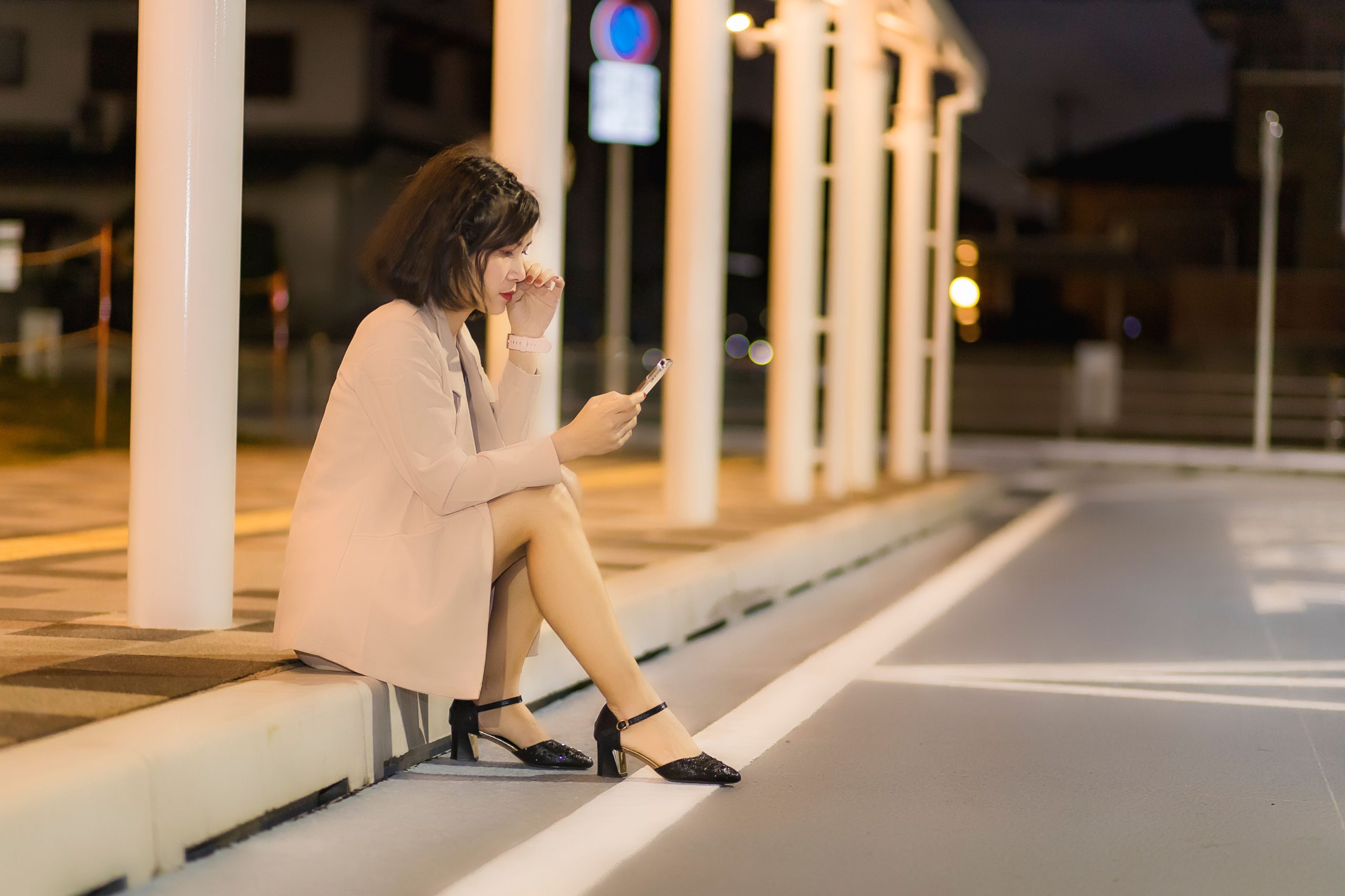 Femme assise utilisant son téléphone la nuit