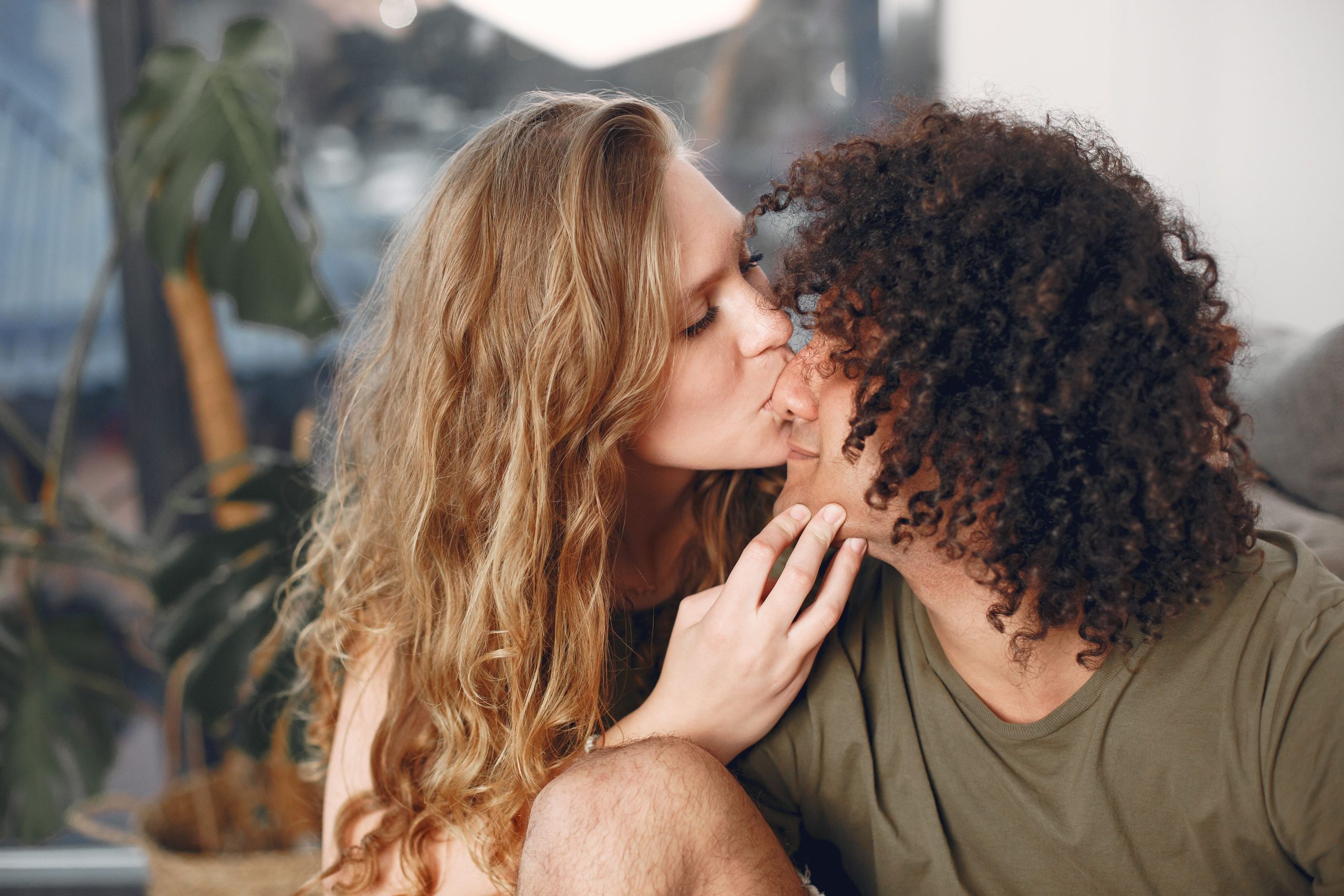 Couple partageant un baiser tendre chez eux