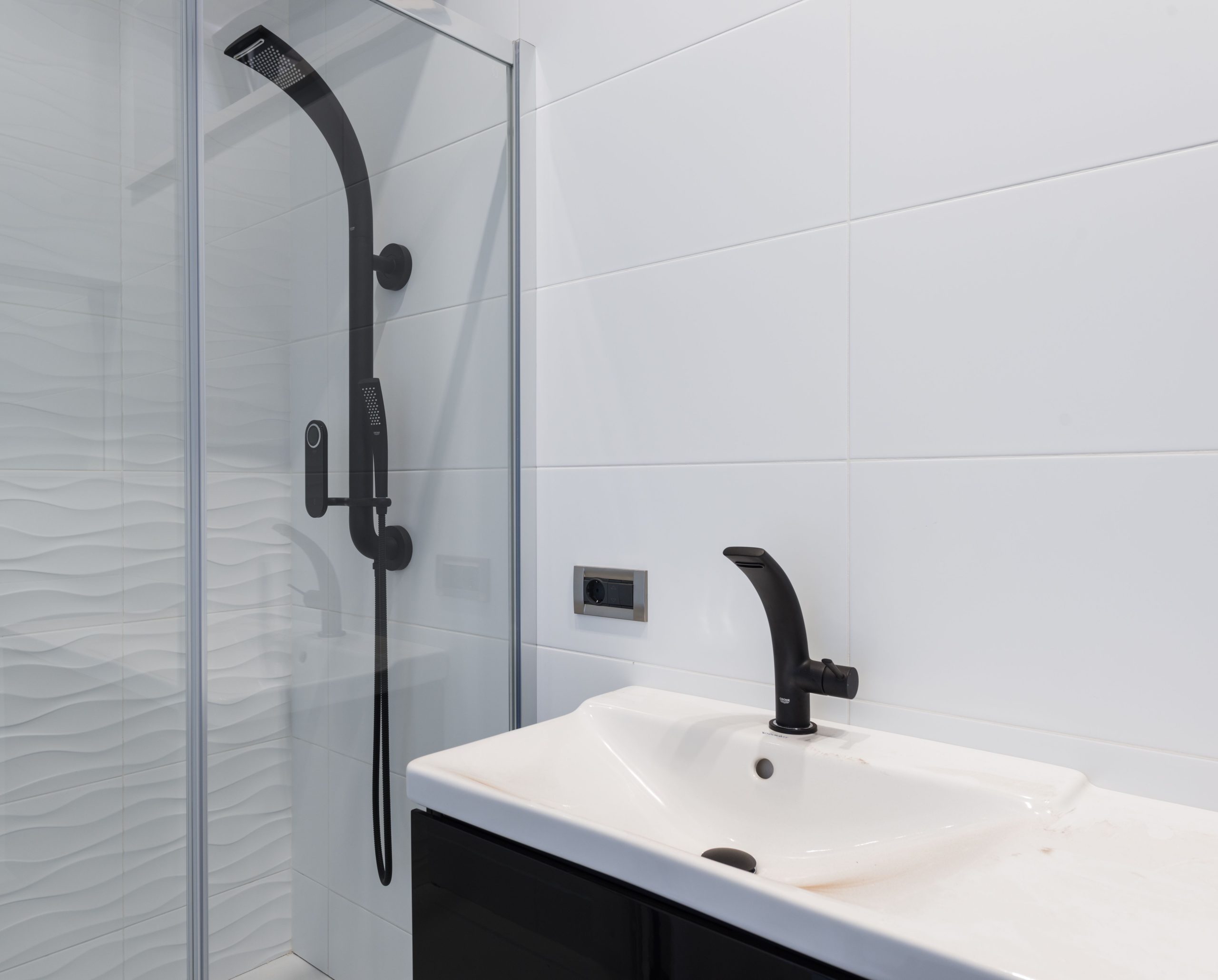 Douche avec robinetterie noire et paroi vitrée