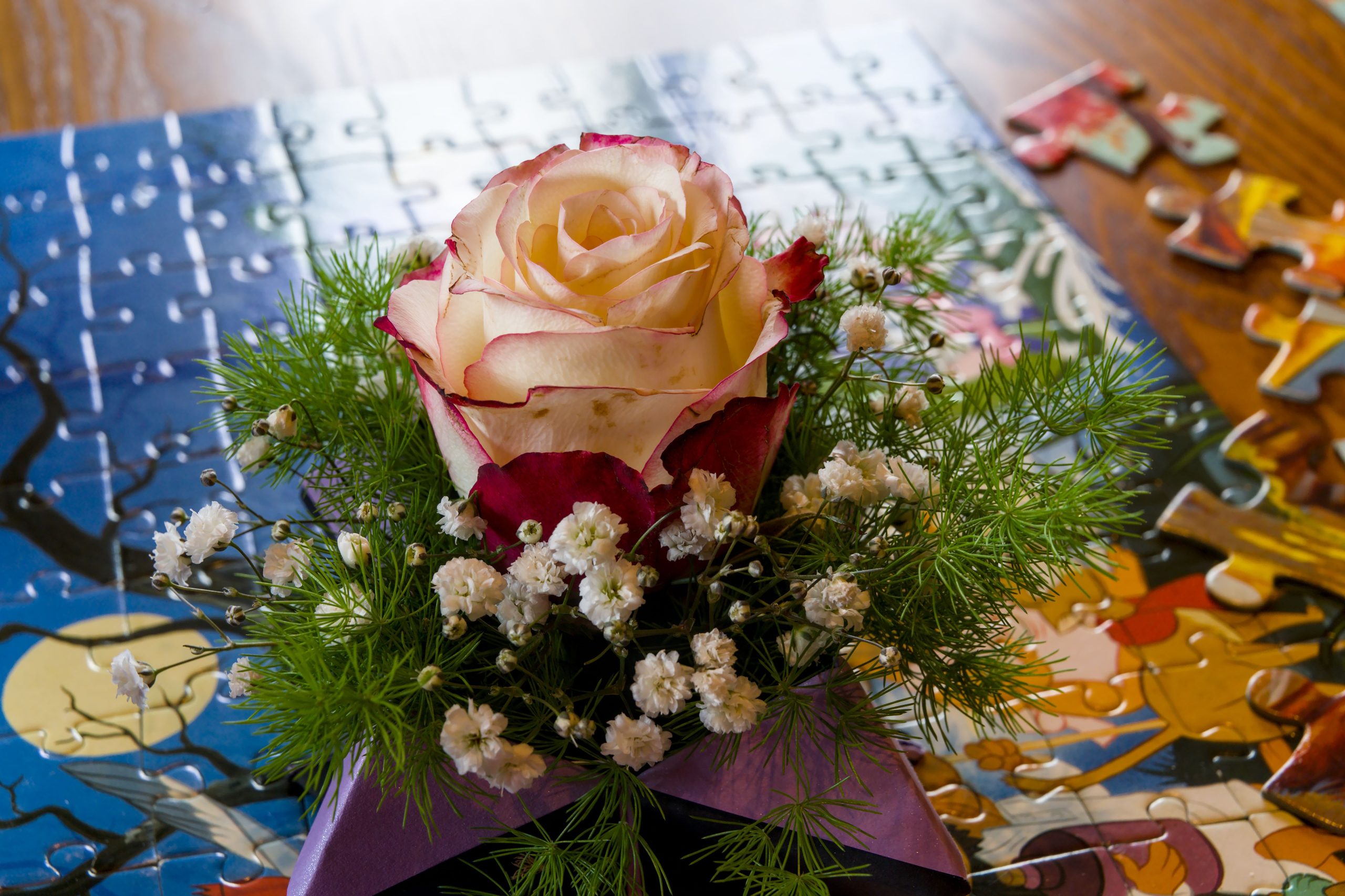 Bouquet de roses posé sur un puzzle inachevé