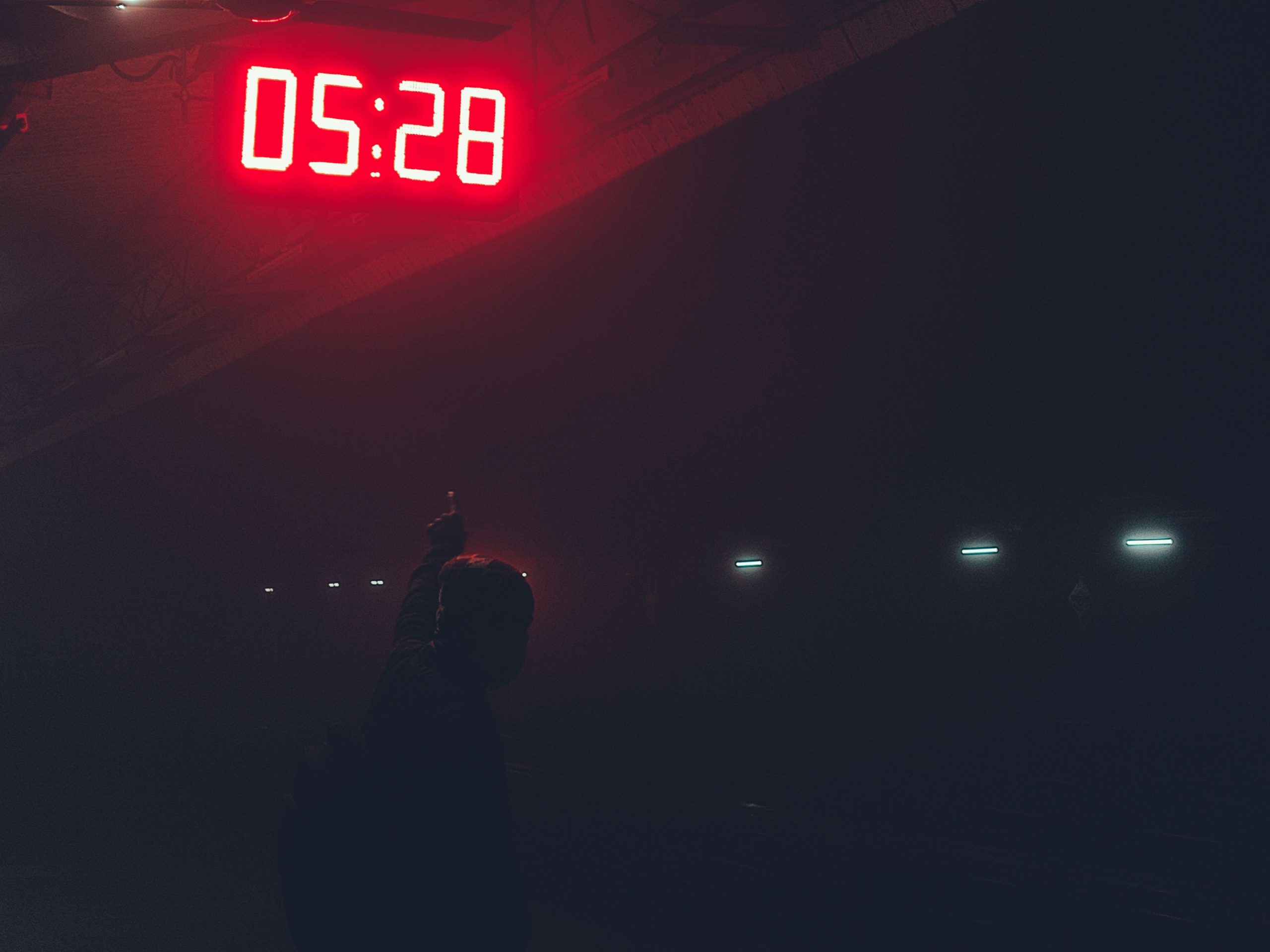 Silhouette pointant horloge numérique illuminée
